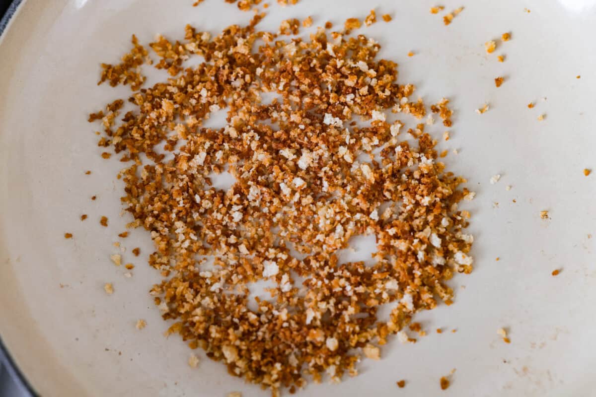 Panko bread crumbs browning in a pan with. butter.