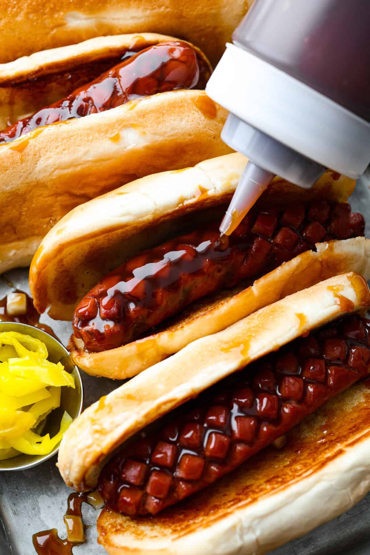 Here in Utah, J. Dawgs is basically a religion! Their hot dogs are THAT good. The sweet, tangy, smoky sauce? Life-changing! Make this copycat J Dawgs sauce at home and you’ll never look at ketchup the same way again. Someone squeezing J Dawgs sauce on a hot dog.