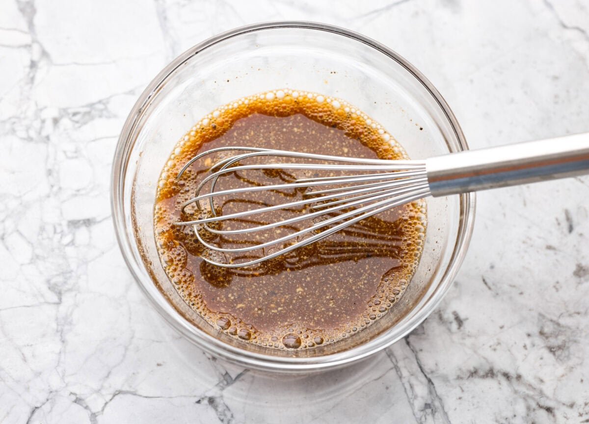 Stop making boring pork chops. You NEED this pork chop marinade, with soy sauce, brown sugar, garlic, Dijon, and citrus! It all comes together for the most juicy, tender, flavor-packed pork chop you've ever had! Marinade ingredients whisked together in a bowl.